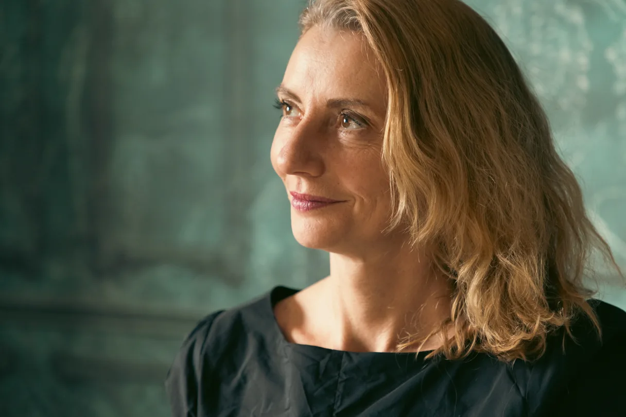 A woman looking thoughtfully into the distance in soft window light